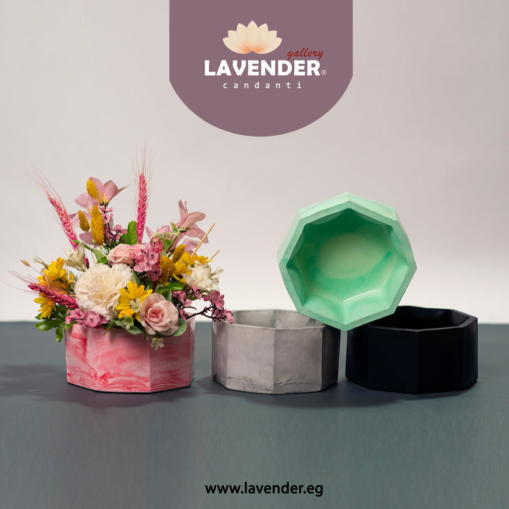 Decorative flower arrangement in a pink pot with geometric containers on 