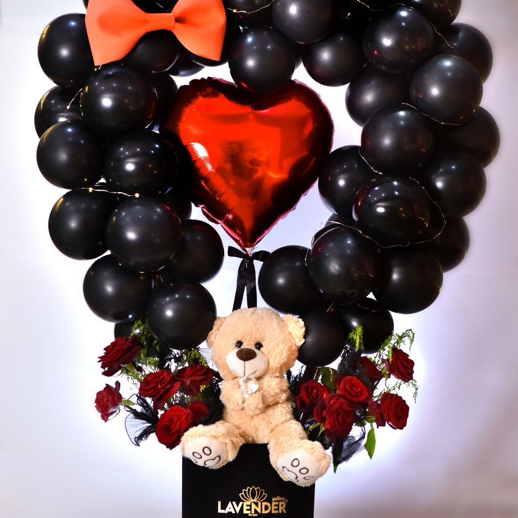 Heart-shaped balloon arrangement with a teddy bear and red roses, featuring the brand 'LAVENDER'.